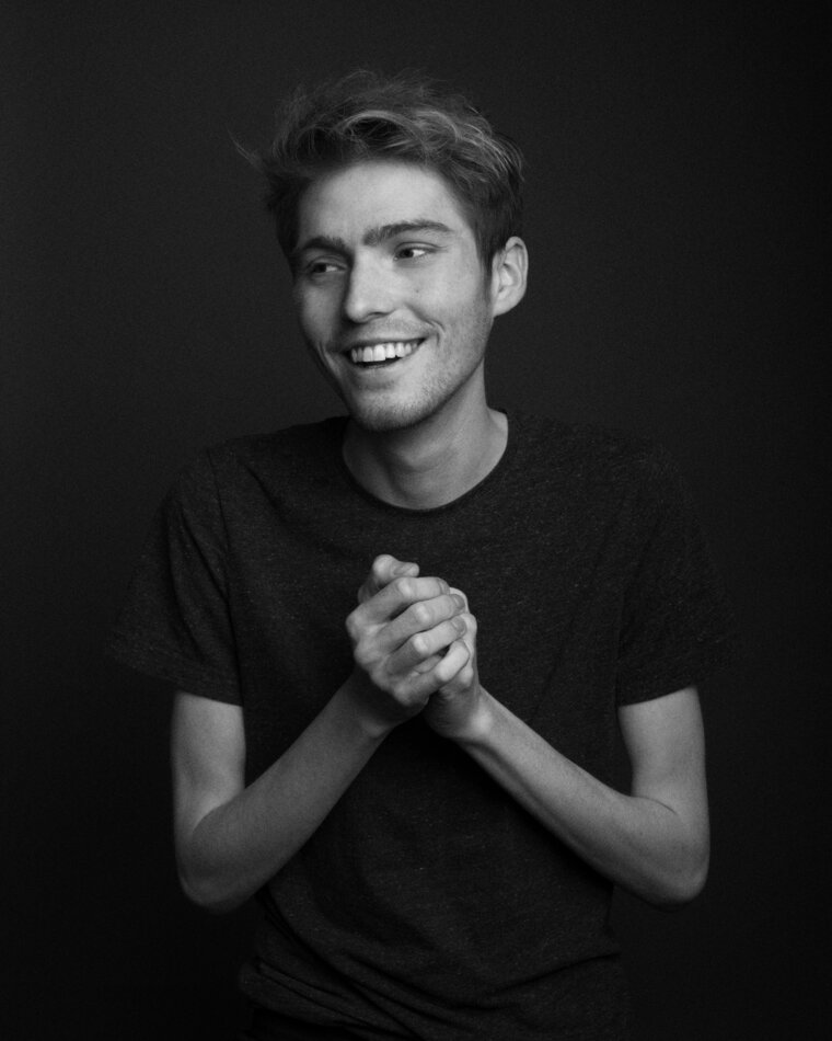 Travis Michael Flores, smiling with hands clasped